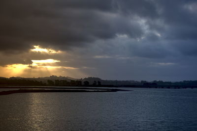 Scenic view of sea against dramatic sky during sunset