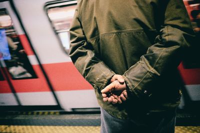 Rear view of a man waiting at railway station platform