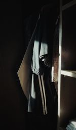 Clothes in a dark room wardrobe lit by the sun