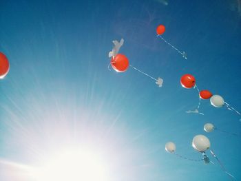 Low angle view of balloons against blue sky