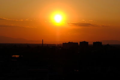 Silhouette buildings against sky during sunset