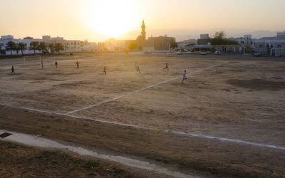 Group of people walking in city at sunset