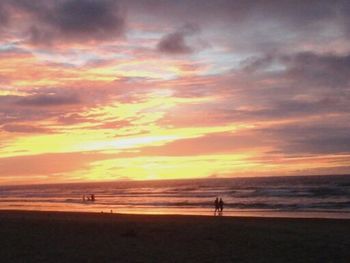 Scenic view of beach against cloudy sky