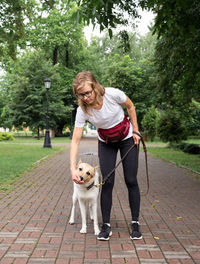 Young caucasian woman training her dog in a park. dog obedience training