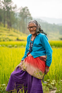 Portrait of senior woman wearing traditional clothing standing in farm