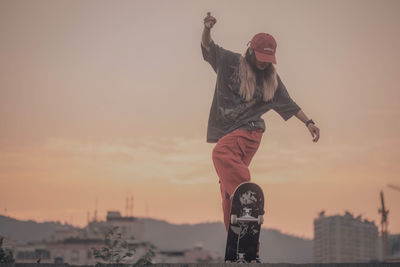 Low section of man standing against sky during sunset