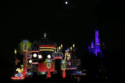 Illuminated buildings against sky at night