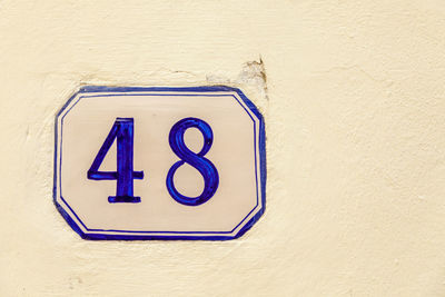 Close-up of number 48 on white wall