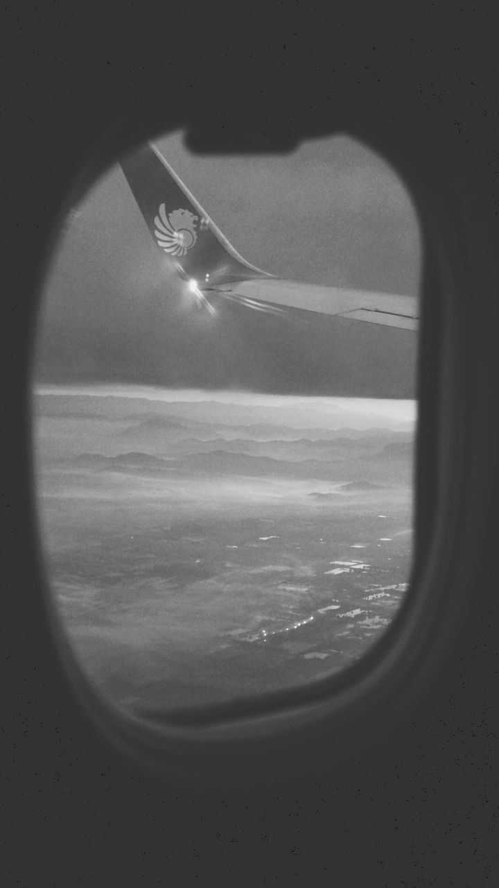 CLOSE-UP OF AIRPLANE WINDOW OVER SEA