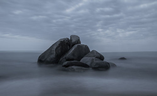 Rocks in sea against sky