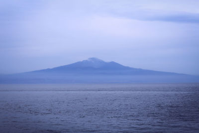 Scenic view of sea and mountains against sky