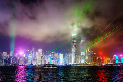 Illuminated buildings in city against sky at night