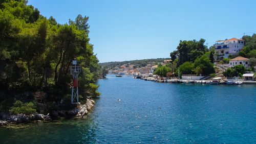 Canal amidst trees against blue sky