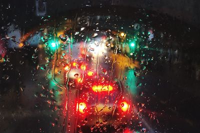 Illuminated lights seen through wet glass window