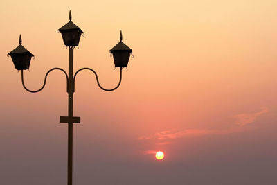 Low angle view of street light against sky at sunset