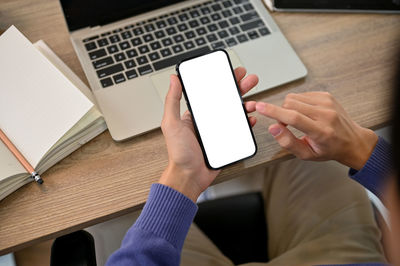 Cropped hands of woman using digital tablet