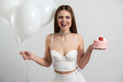 Portrait of a smiling young woman holding balloons