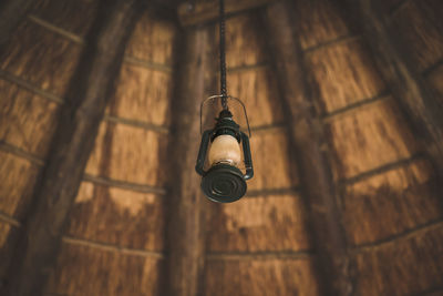 Low angle view of light bulb hanging on wall