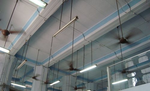 Low angle view of illuminated lighting equipments hanging at ceiling