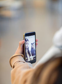 Hand holding cell phone while taking selfie