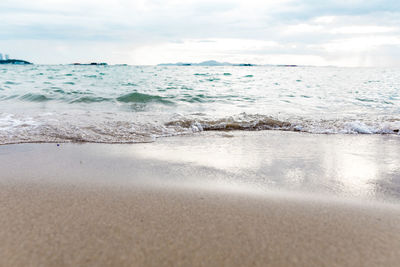 Close up of sea ocean wave on sandy beach and sky