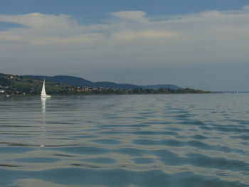 Scenic view of sea and mountains against sky