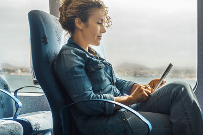 Side view of young woman using mobile phone