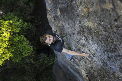 Portrait of man climbing on rock