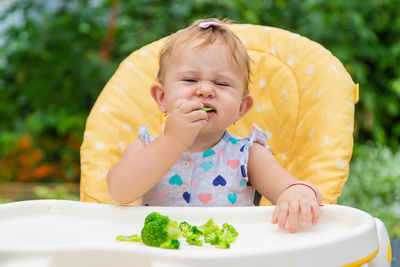 Cute baby eating broccoli