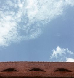 Roof of building against cloudy sky