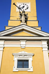Low angle view of sculpture on building against sky