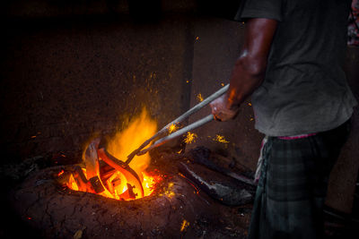 Midsection of man working on barbecue grill