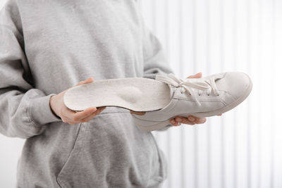 Midsection of woman holding shoe