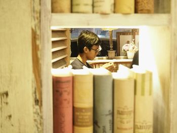 Boy seen from bookshelf in library