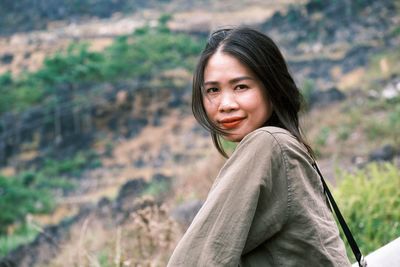 Portrait of young woman standing on field