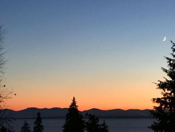 Scenic view of silhouette mountains against clear sky during sunset