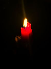 Close-up of lit candle in dark room