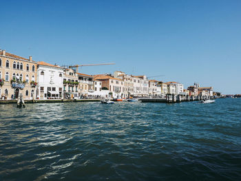 Canal against buildings in city on sunny day