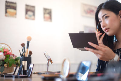 Young woman using smart phone on table