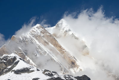 Low angle view of snowcapped mountains against sky