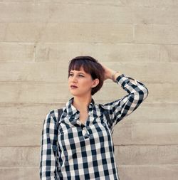 Young woman standing against wall