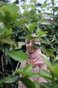 Portrait of woman with green leaves