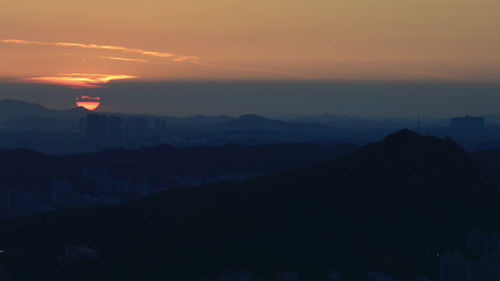 Scenic view of silhouette mountains against sky at sunset