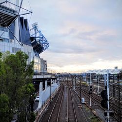 Train on railroad tracks against sky during sunset