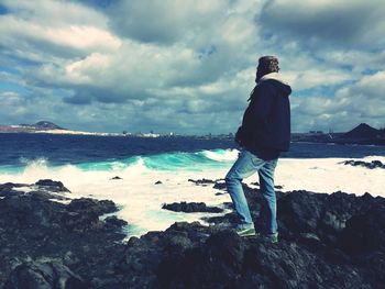 Rear view of man standing on rock