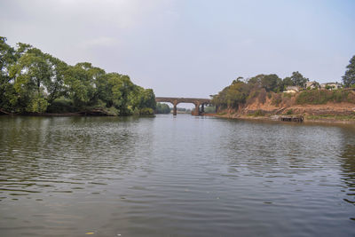 Arch bridge over river against sky