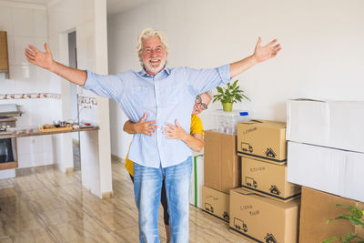 Portrait of senior woman embracing husband while standing at home