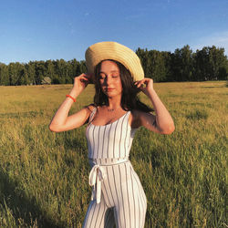 Full length of woman wearing hat standing on field