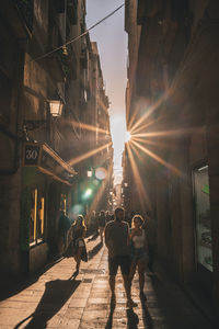 Rear view of people walking on street in city