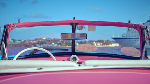 Close-up of pink convertible against blue sky